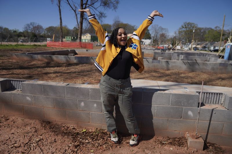 Lauren celebrating at the Langston Park construction site, arms raised in joy